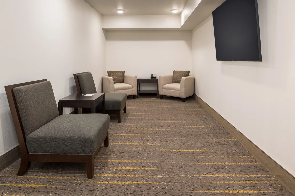 A comfortable seating area featuring a small table and a television, designed for intimate conversations, relaxation, or watching TV. The room's arrangement suggests a space suitable for solo downtime or small group enjoyment, echoing the multi-functional aspect of the living area.