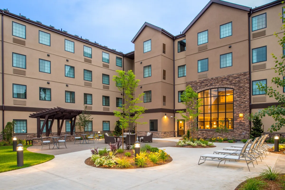 This image captures the central courtyard of Staybridge Hillsboro North, featuring large windows that connect the indoor and outdoor spaces, and a cozy pergola with seating. The area is designed for relaxation and social interactions, perfect for families to unwind after a day of exploring local attractions.